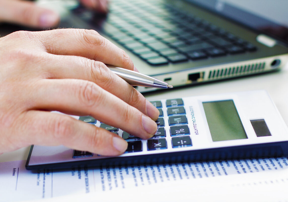 Detail of Business man in dark suit whit calculator